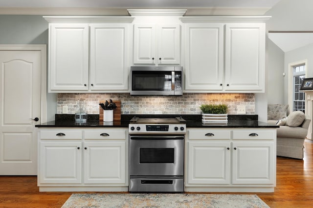 kitchen featuring tasteful backsplash, stainless steel appliances, light wood-type flooring, and white cabinets