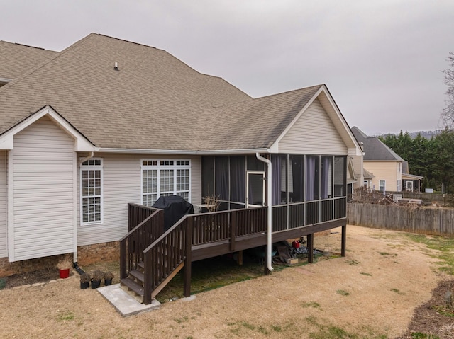 rear view of house featuring a sunroom and a deck