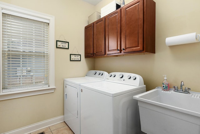 washroom with cabinets, light tile patterned flooring, washer and dryer, and sink