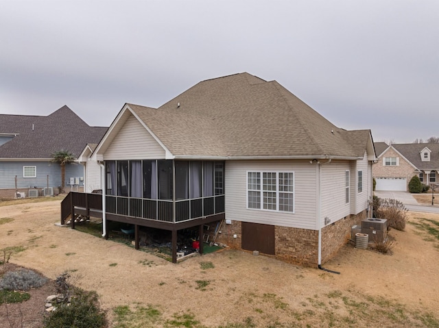 rear view of house featuring a sunroom and central air condition unit