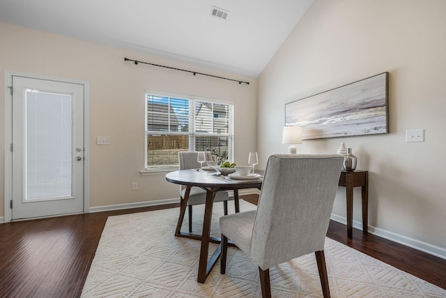 dining space featuring hardwood / wood-style flooring and vaulted ceiling