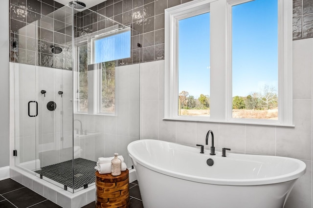 bathroom featuring separate shower and tub and tile walls