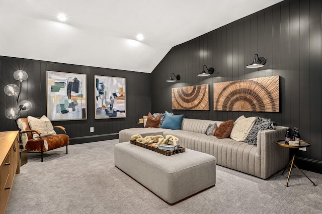 cinema with vaulted ceiling, light colored carpet, and wood walls