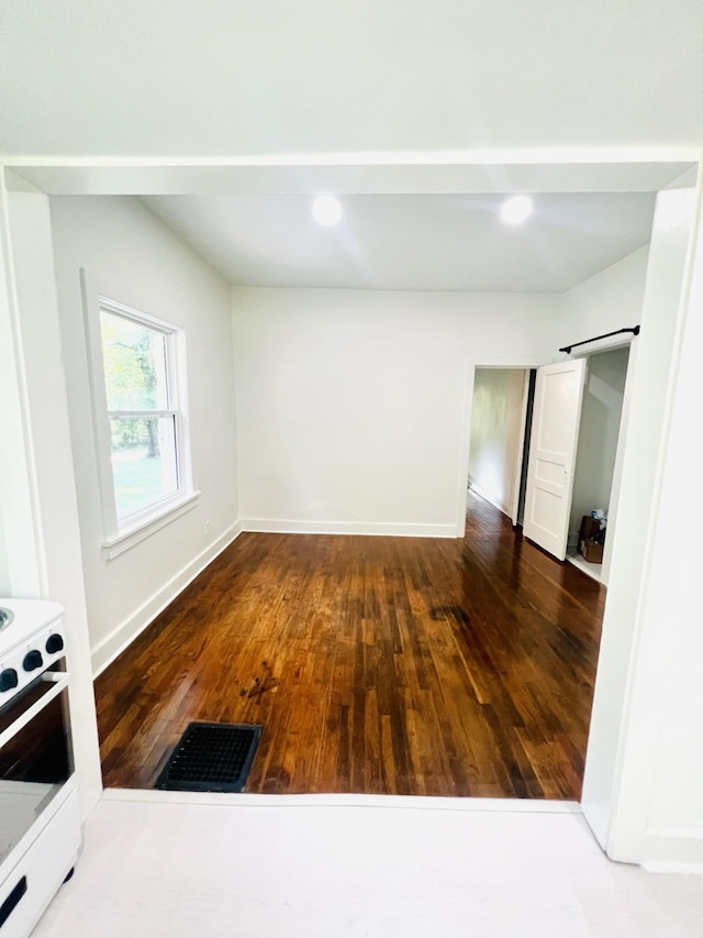 interior space with dark hardwood / wood-style floors and a barn door