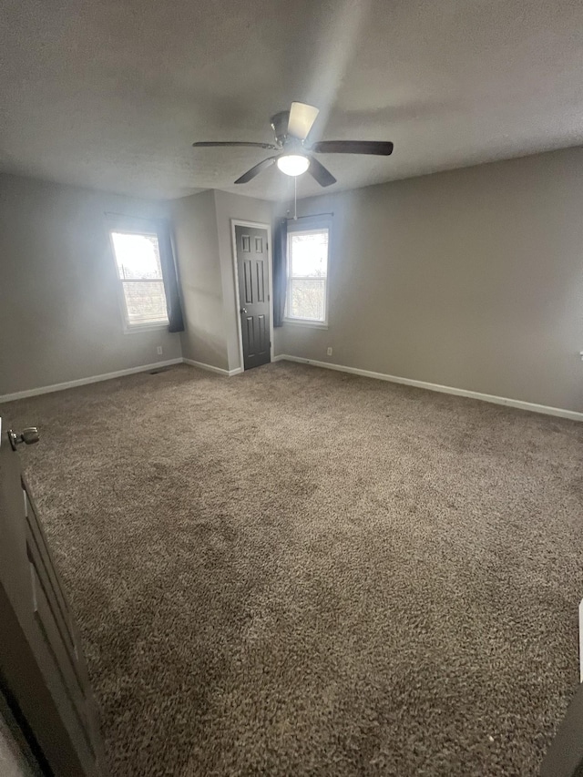 carpeted spare room with ceiling fan