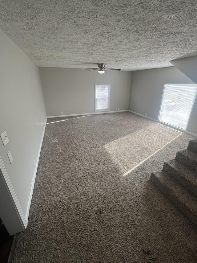 unfurnished room featuring ceiling fan, carpet floors, and a textured ceiling