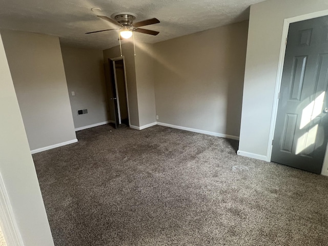 carpeted spare room featuring ceiling fan and a textured ceiling