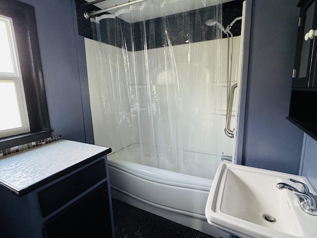 bathroom featuring shower / bathtub combination with curtain, sink, and a wealth of natural light