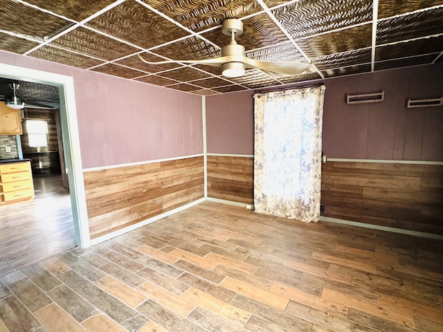 spare room featuring hardwood / wood-style flooring and wood walls