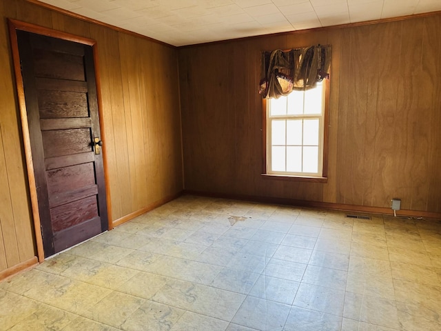 unfurnished room featuring wooden walls