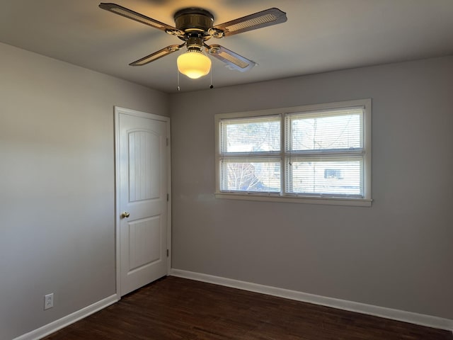 unfurnished room featuring dark wood-type flooring and ceiling fan