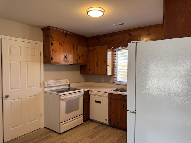 kitchen with sink, white appliances, and light wood-type flooring