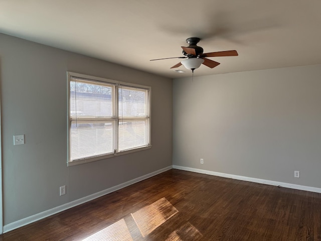 spare room with dark wood-type flooring and ceiling fan