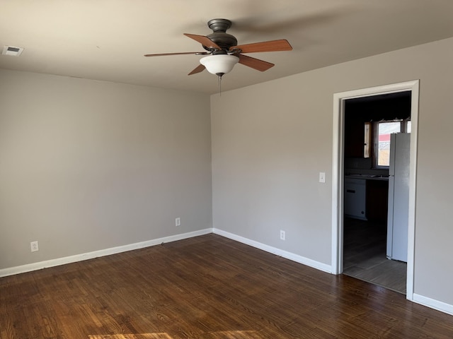 spare room featuring dark hardwood / wood-style flooring and ceiling fan