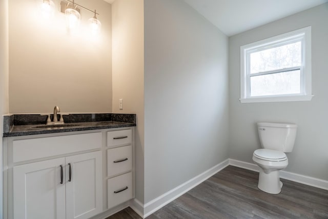 bathroom with hardwood / wood-style flooring, vanity, and toilet