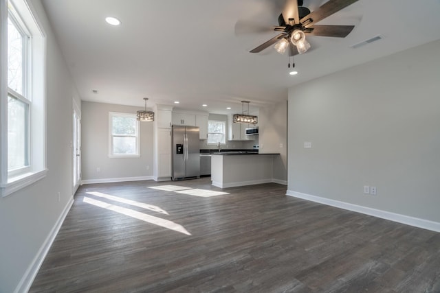 unfurnished living room with dark hardwood / wood-style floors and ceiling fan