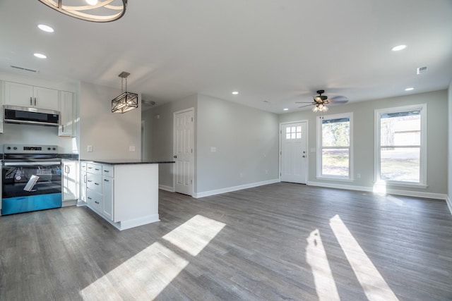 kitchen featuring stainless steel appliances, hardwood / wood-style floors, pendant lighting, and white cabinets