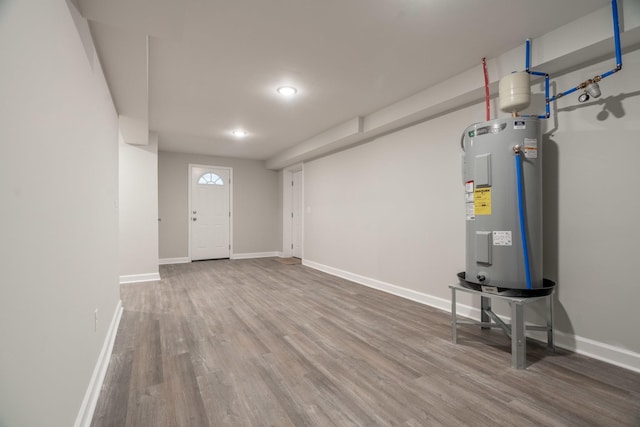 basement with hardwood / wood-style flooring and electric water heater