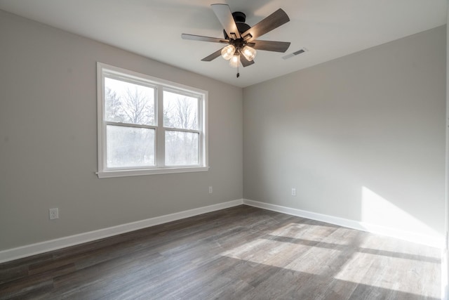 empty room with dark hardwood / wood-style flooring and ceiling fan