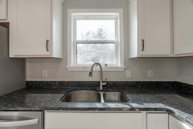 kitchen with white cabinetry, sink, and dark stone countertops