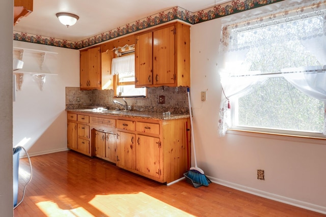 kitchen with sink, light hardwood / wood-style flooring, and decorative backsplash