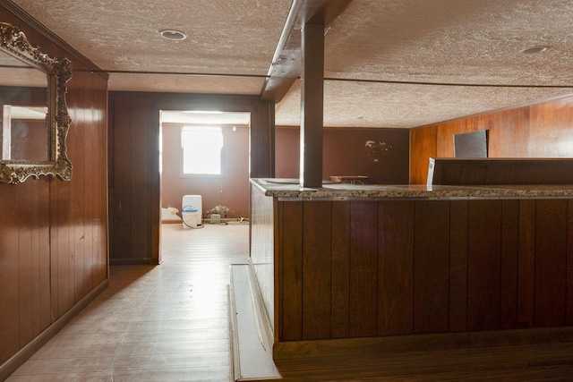 interior space featuring light hardwood / wood-style floors, a textured ceiling, and wood walls