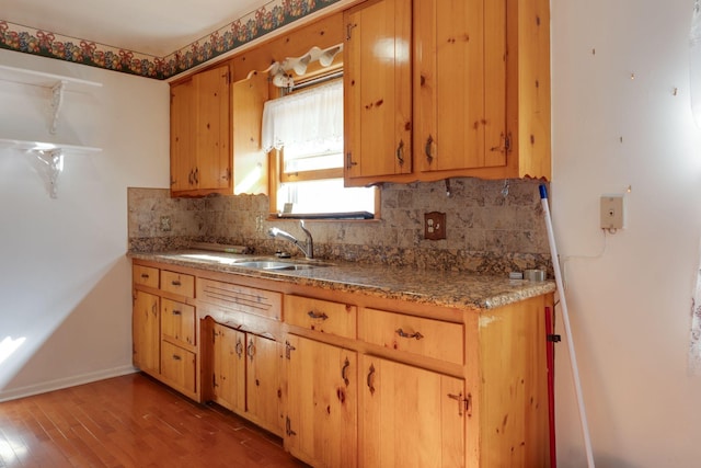 kitchen featuring hardwood / wood-style flooring, sink, and decorative backsplash