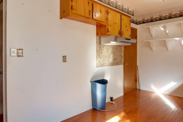 kitchen with hardwood / wood-style flooring and backsplash