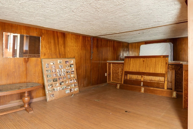 interior space with hardwood / wood-style flooring, wooden walls, and a textured ceiling