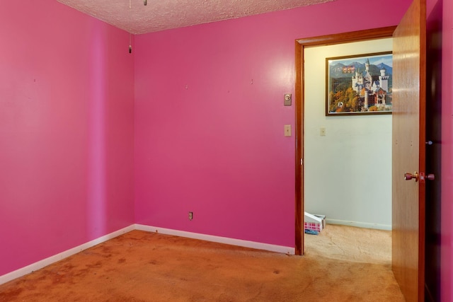 carpeted empty room with a textured ceiling