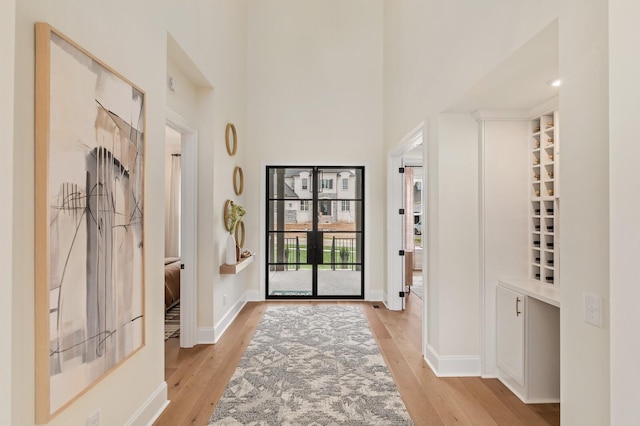 entryway with a high ceiling and light wood-type flooring