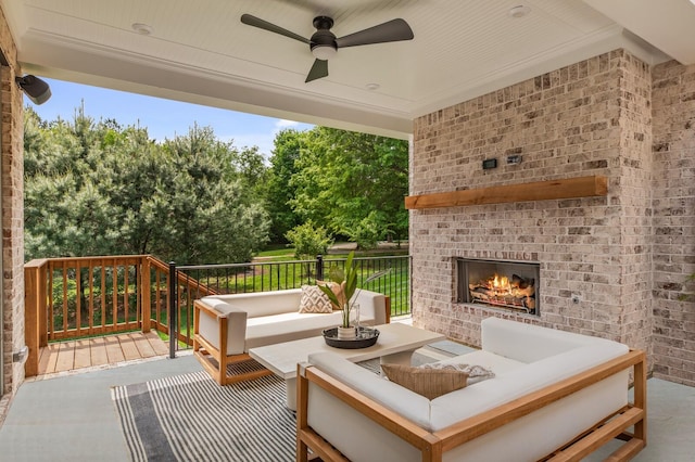 deck with ceiling fan, a patio area, and an outdoor living space with a fireplace