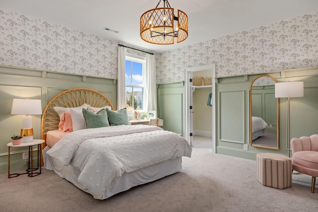 bedroom featuring light carpet and a chandelier