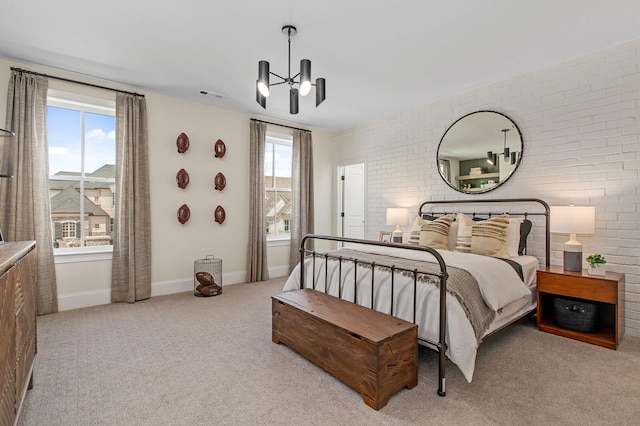 bedroom with brick wall, light carpet, and a notable chandelier