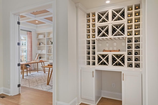 interior space with coffered ceiling, beam ceiling, and light wood-type flooring