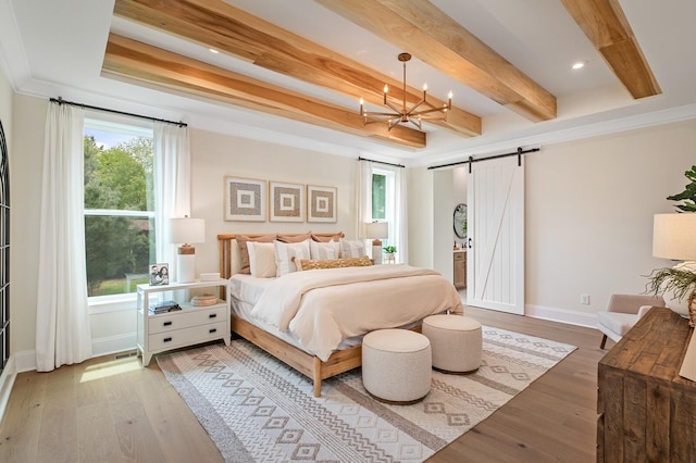 bedroom featuring beamed ceiling, a barn door, a chandelier, and hardwood / wood-style floors