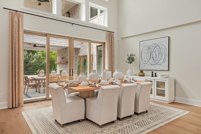 dining room featuring a towering ceiling and wood-type flooring