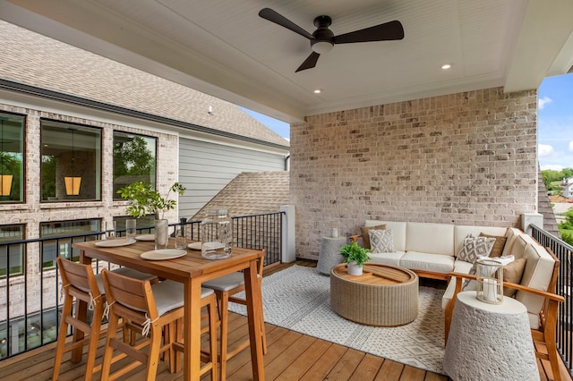 wooden deck featuring an outdoor living space and ceiling fan