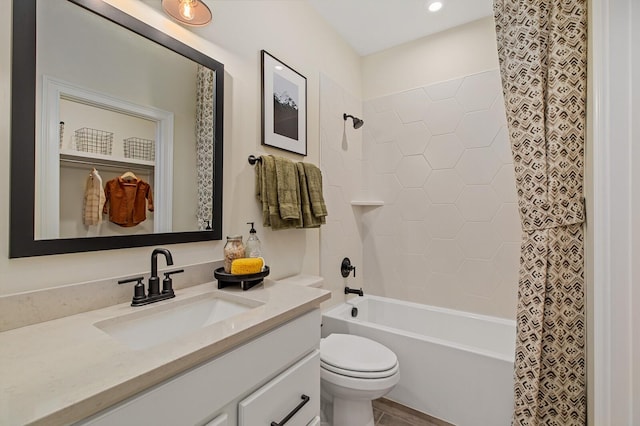 full bathroom featuring tiled shower / bath combo, vanity, and toilet