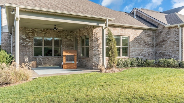 back of house featuring ceiling fan, a patio, and a lawn