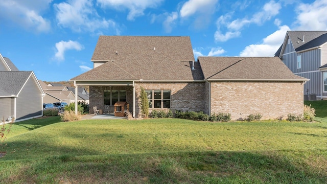 rear view of property with a patio and a lawn