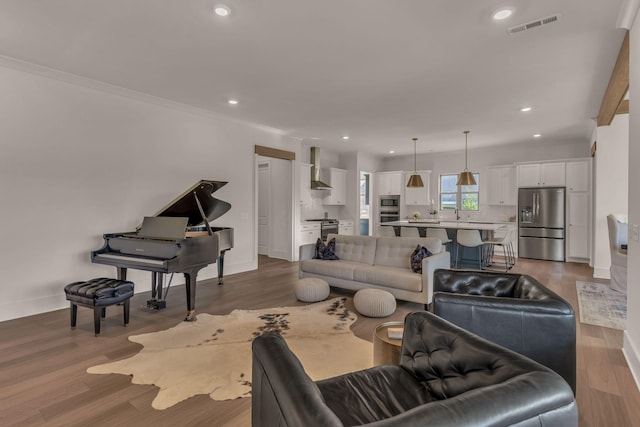 living room with crown molding and hardwood / wood-style floors