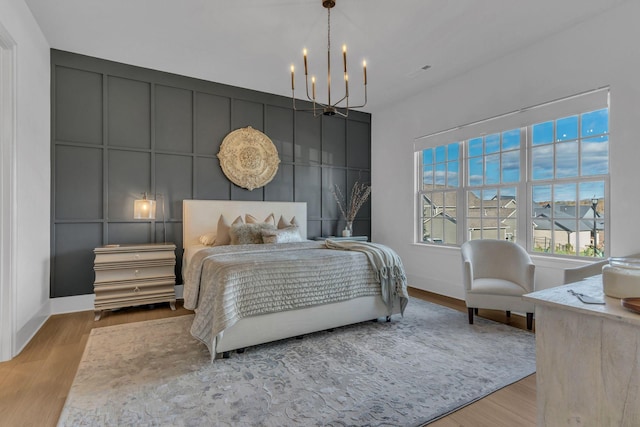 bedroom with light hardwood / wood-style floors and a chandelier