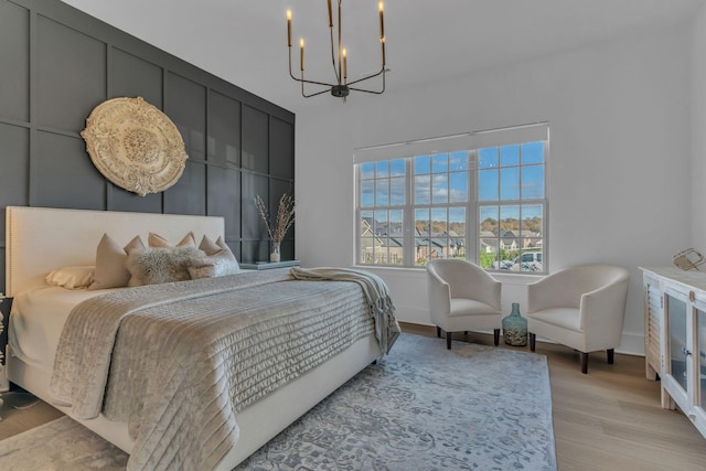 bedroom with a notable chandelier and light hardwood / wood-style floors