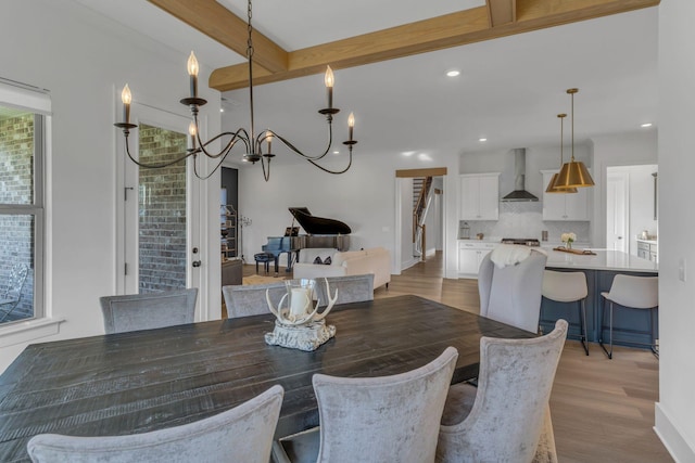 dining space featuring beamed ceiling and light wood-type flooring