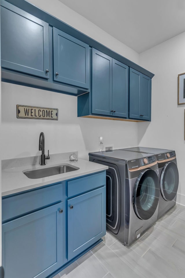 washroom with cabinets, sink, and washing machine and clothes dryer