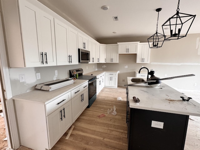 2363 Pea Ridge Rd, Clarksville, TN 37040 - kitchen with light wood finished floors, an island with sink, a sink, and appliances with stainless steel finishes