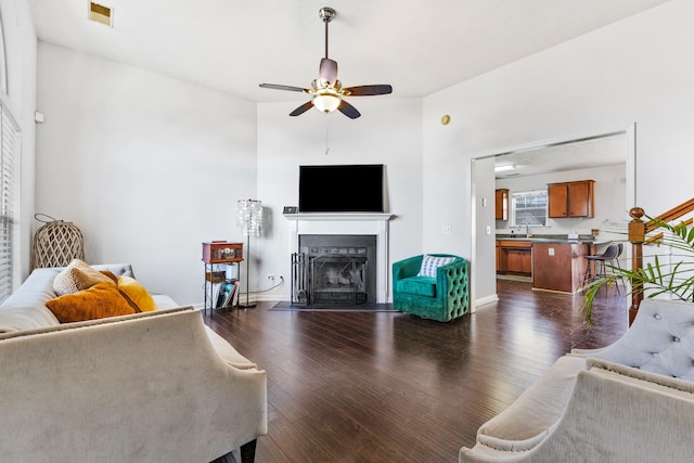 living room with ceiling fan, dark hardwood / wood-style flooring, and sink