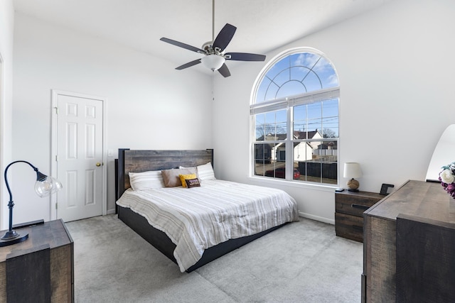 carpeted bedroom featuring ceiling fan and high vaulted ceiling