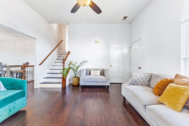 living room featuring dark wood-type flooring and ceiling fan